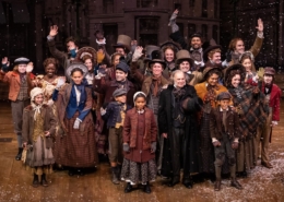 The cast of A Christmas Carol poses for a photo onstage
