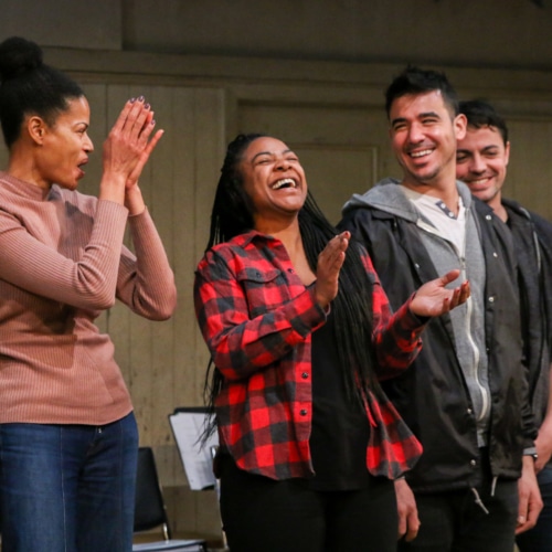 Four young adult actor stand in a row, smiling and clapping, at a DCPA Community Engagement event