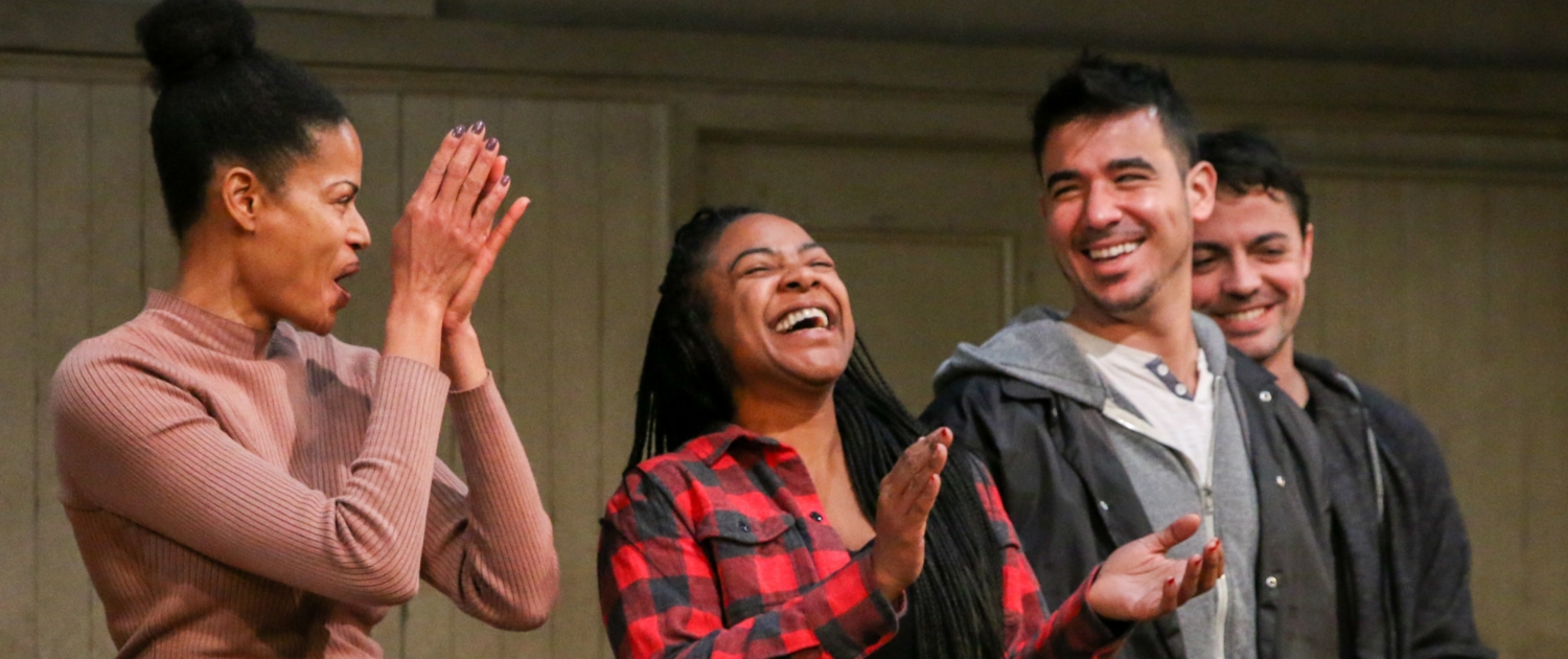 Four young adult actor stand in a row, smiling and clapping, at a DCPA Community Engagement event