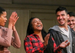 Four young adult actor stand in a row, smiling and clapping, at a DCPA Community Engagement event