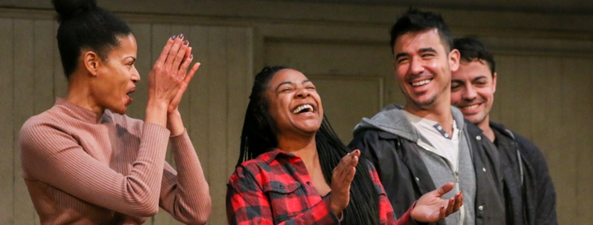 Four young adult actor stand in a row, smiling and clapping, at a DCPA Community Engagement event