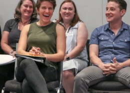 People seated in rows laugh and smile