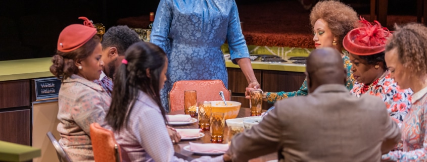 Chavez Ravine stands at the head of a table and prays with the cast of In the Upper Room, all dressed in their Sunday best