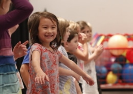 Children in acting class stand in a line, smiling