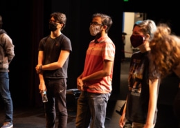 Students stand in a circle onstage in the Weeks Conservatory Theatre