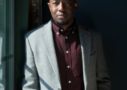 Jamil Jude wearing a suit in a dark room