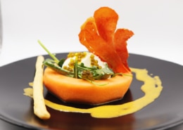 A cantaloupe and burrata salad is beautifully presented on a plate