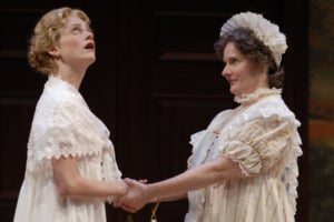 One woman holds another's hands as she looks upward