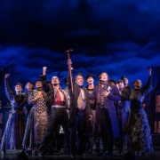 The cast of Moulin Rouge poses at the front of the stage