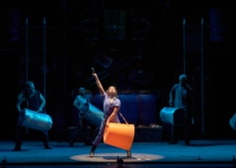 The cast of STOMP performs with large buckets