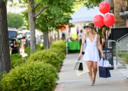 A fashionable woman walks down a sidewalk
