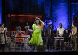 A woman dances center stage while others look on in Hadestown