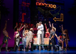 Vivian and Edward embrace surrounded by people in Pretty Woman: The Musical