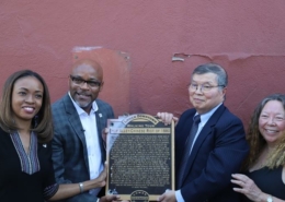 A group of people stand with a plaque