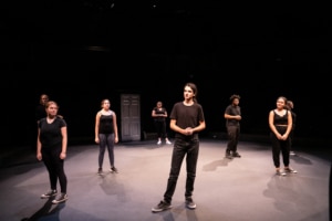 A group of DCPA education students stand spaced apart onstage