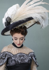 A woman in elegant dress with a large feathered hat