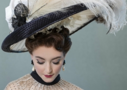 A woman in elegant dress with a large feathered hat