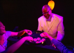 A person holds out a tray of snacks to several hands