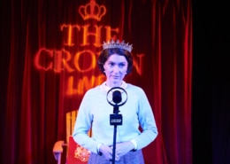A woman stands in front of an old fashioned microphone