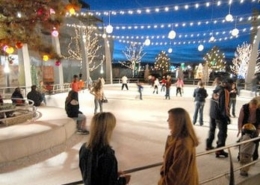 People mill around and skate at an outdoor ice rink