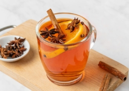 A glass of wassail decorated with spices