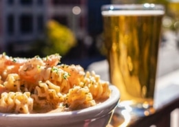 A plate next to a full cup of beer at Nola Jane