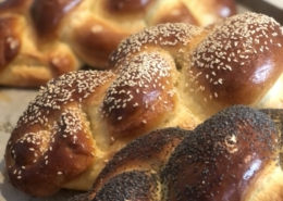 A close up of three loaves of baked challah