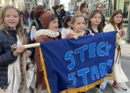 A group of students dressed in costume march in the DPS Shakespeare Festival parade