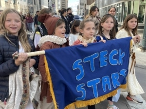 A group of students dressed in costume march in the DPS Shakespeare Festival parade