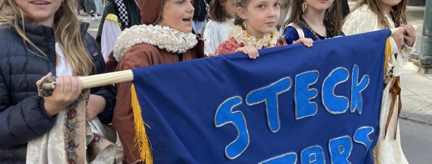 A group of students dressed in costume march in the DPS Shakespeare Festival parade