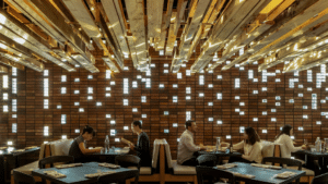 The dining room of Uchi. Couples are seated in booths along the wall and modern, square lights hang from the ceiling