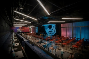 The main listening room at Dazzle's new location. Many red chairs circle a small stage for a jazz band.