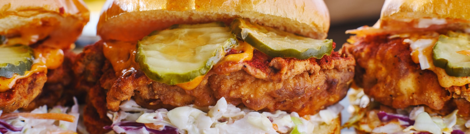 Three Nashville hot chicken sandwiches lined up for their beauty shot