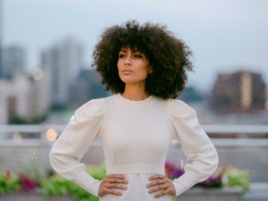 Dzirae Gold wears a white top, her hands on her hips.