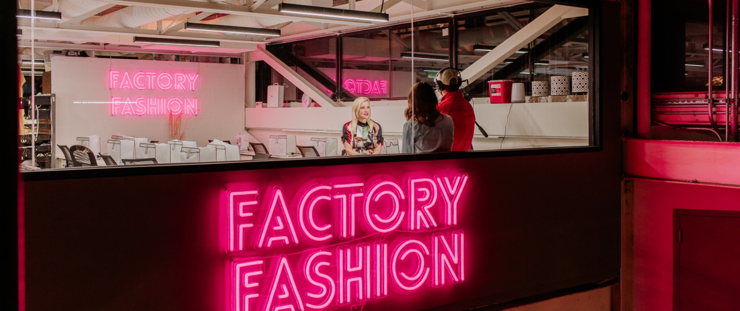 Factory Fashion glows in neon pink lettering outside the workshop in Stanley Marketplace.