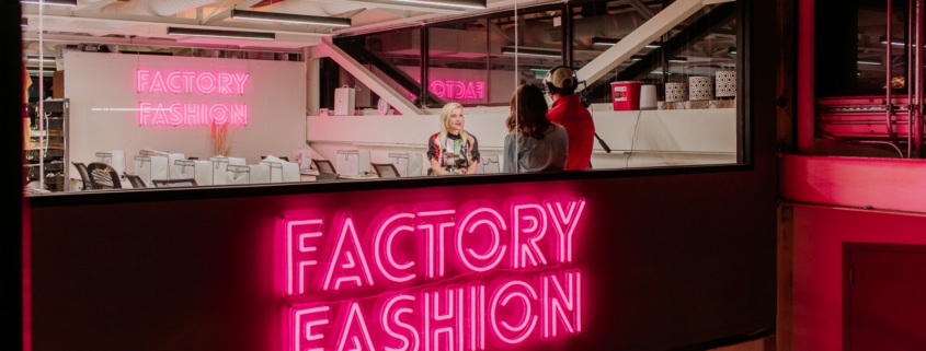 Factory Fashion glows in neon pink lettering outside the workshop in Stanley Marketplace.