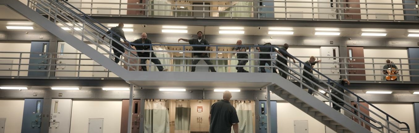 Prisoners perform along a stairway in the prison