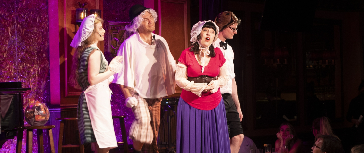 A group of performers sing onstage. They are wearing old-timey costumes and hats thrown on over their regular clothes