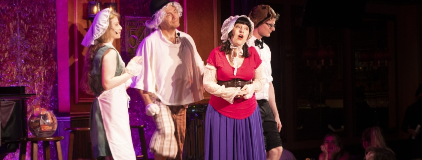 A group of performers sing onstage. They are wearing old-timey costumes and hats thrown on over their regular clothes