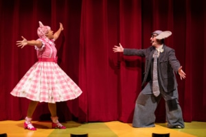 Piggie holds open her arms to Gerald the Elephant, who also holds open his arms. They both grin at each other and prepare to hug.