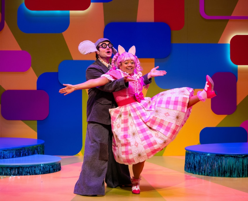 Gerald the Elephant catches Piggie as she leans back in a dance move with one leg kicked up.