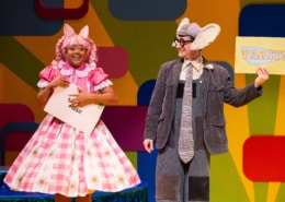 Piggie grins at the audience clutching an envelope addressed to her. Gerald the Elephant grins at Piggie and holds up a card that reads PARTY!