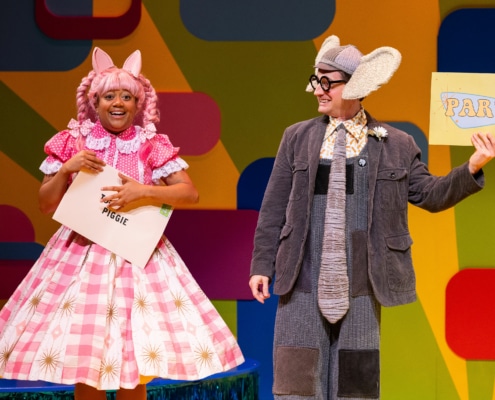 Piggie grins at the audience clutching an envelope addressed to her. Gerald the Elephant grins at Piggie and holds up a card that reads PARTY!